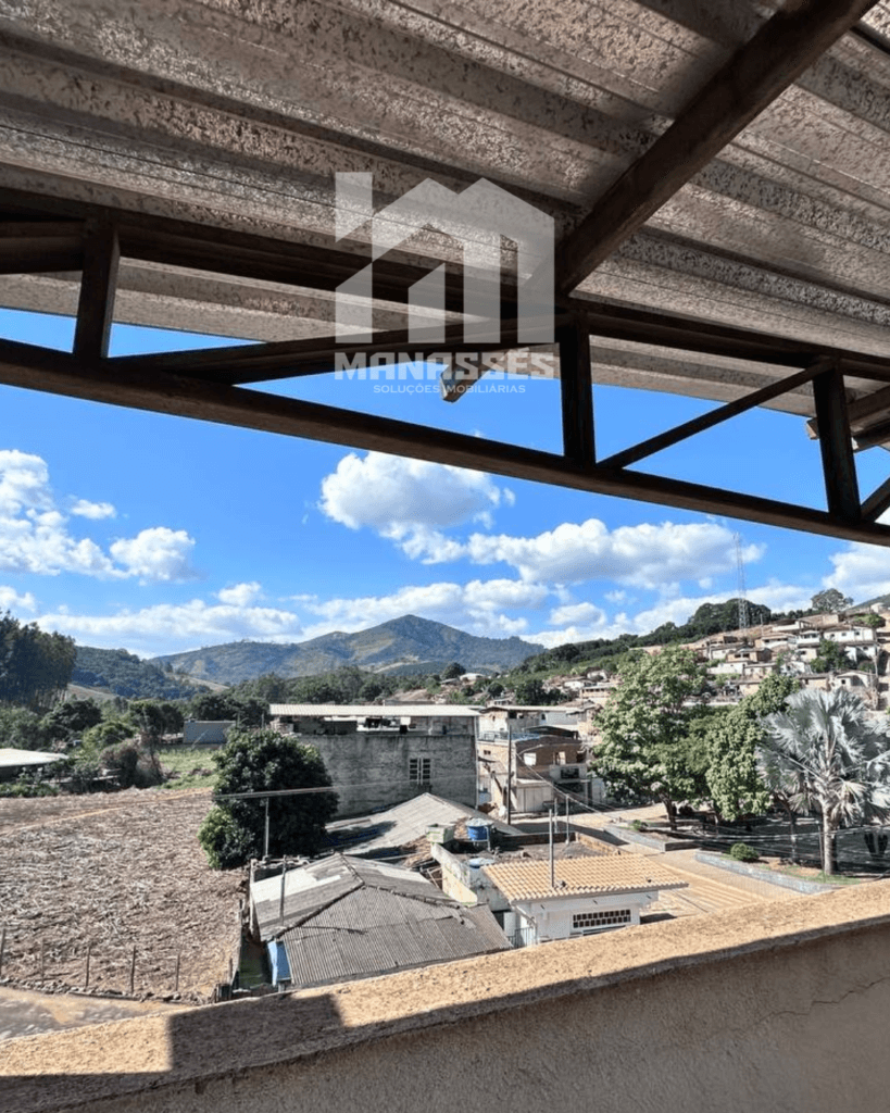 Vista panorâmica da cidade e montanhas a partir de cobertura com telhado metálico – Manassés Soluções Imobiliárias.
