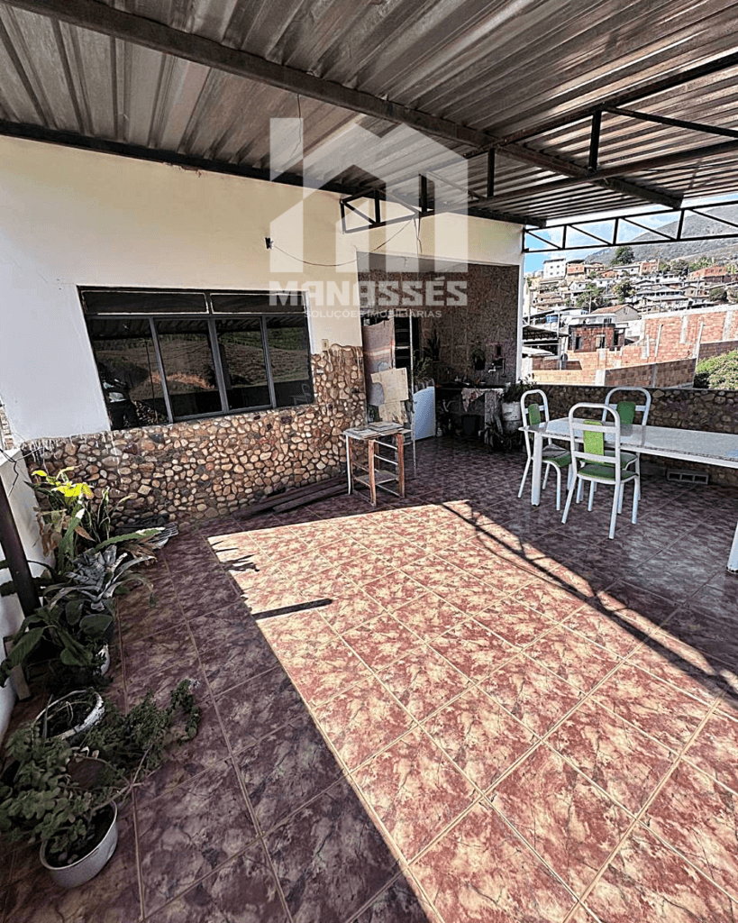 Varanda coberta com piso cerâmico marrom e vista panorâmica para o bairro – Manassés Soluções Imobiliárias.