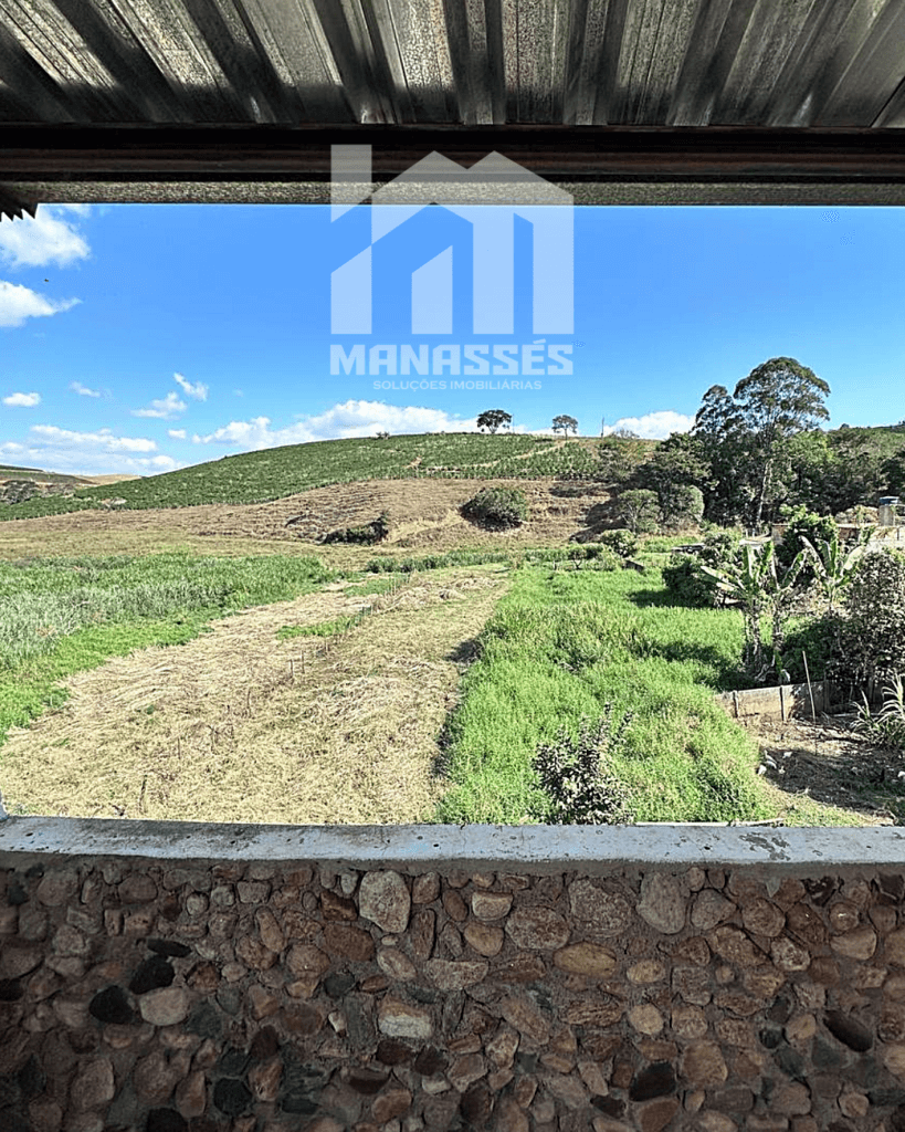 Vista panorâmica para área verde e colinas a partir de varanda coberta – Manassés Soluções Imobiliárias.