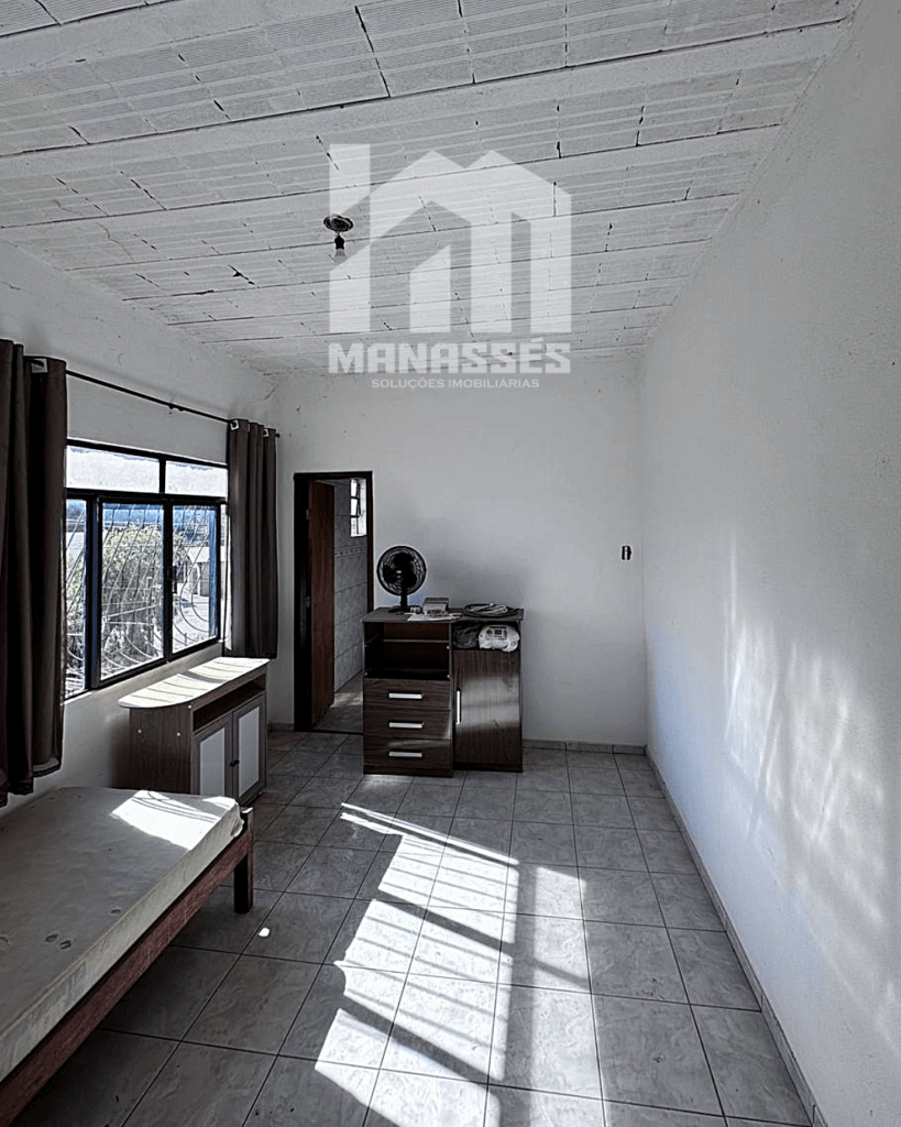 Quarto simples com janelas amplas e iluminação natural – Manassés Soluções Imobiliárias.