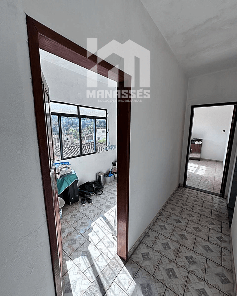 Corredor com acesso a quarto iluminado por janela ampla – Manassés Soluções Imobiliárias.