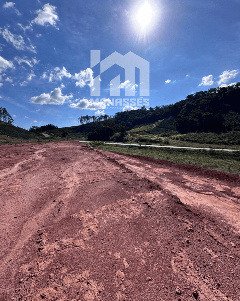Terreno amplo e ensolarado às margens da BR-262 em Manhuaçu/MG, com solo avermelhado e topografia plana, ideal para empreendimentos comerciais ou residenciais.