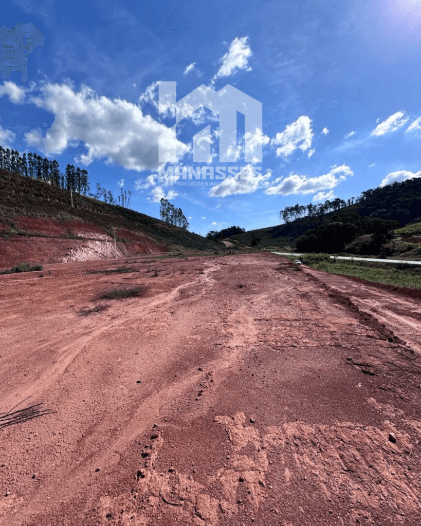 Terreno plano com solo avermelhado às margens da BR-262 em Manhuaçu/MG, ideal para construção, loteamento ou investimento imobiliário.