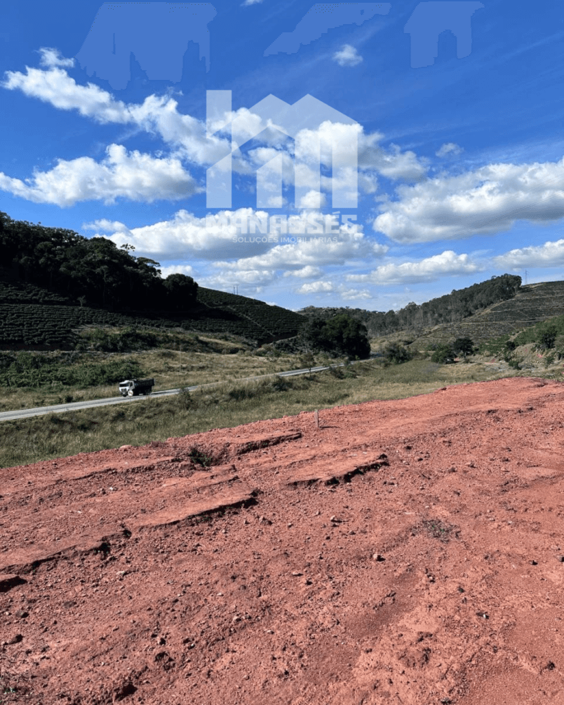 Vista panorâmica de terreno amplo e ensolarado às margens da BR-262 em Manhuaçu/MG, com solo avermelhado, vegetação ao fundo e acesso direto pela rodovia.