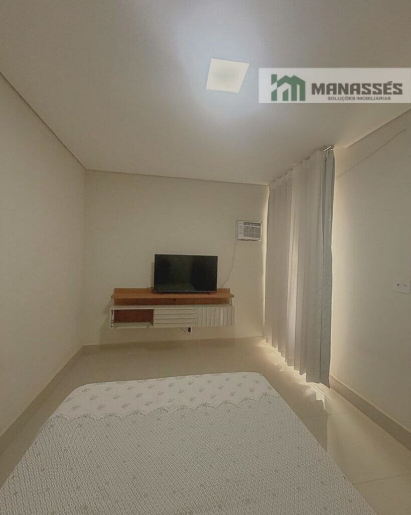 Quarto com ar-condicionado, painel para TV, piso em porcelanato e acabamento moderno em imóvel residencial à venda em Manhuaçu.