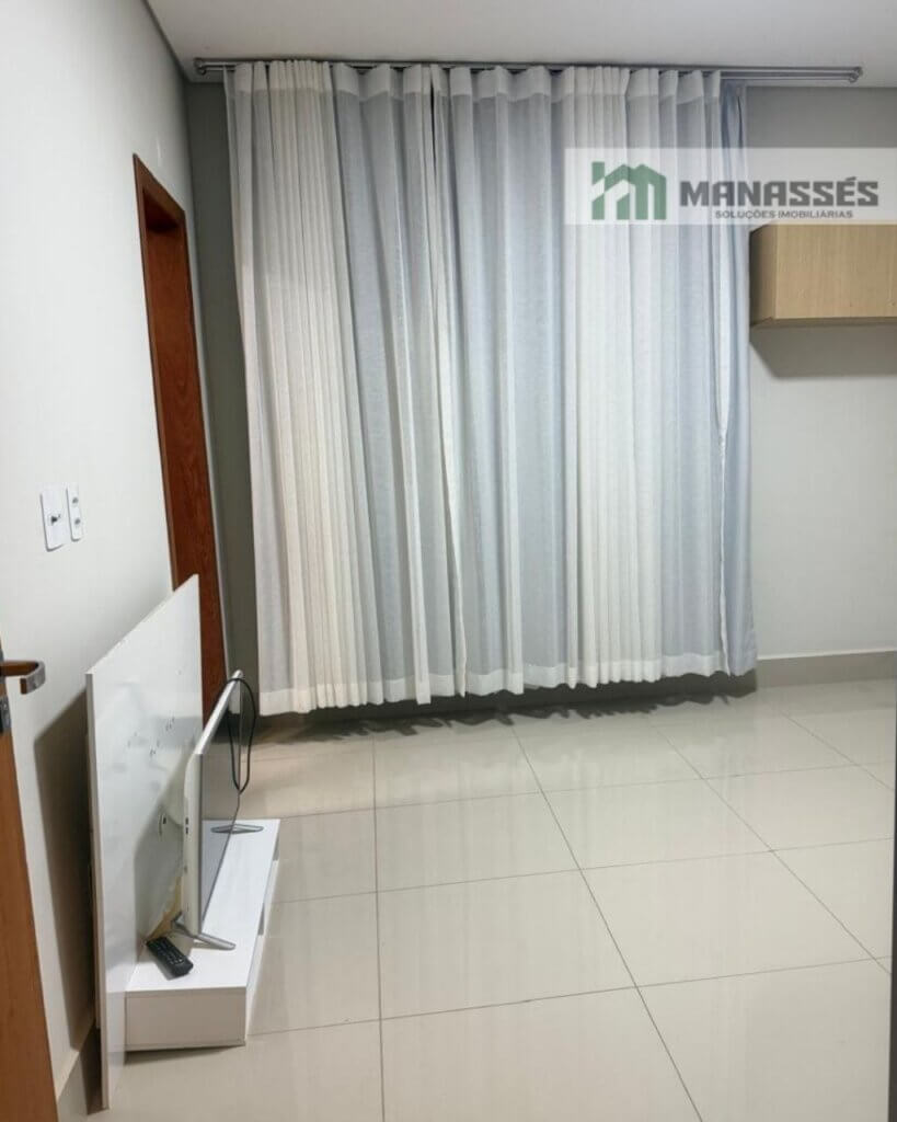 Quarto amplo com piso em porcelanato, cortinas sob medida e acabamento moderno em imóvel residencial à venda em Manhuaçu.