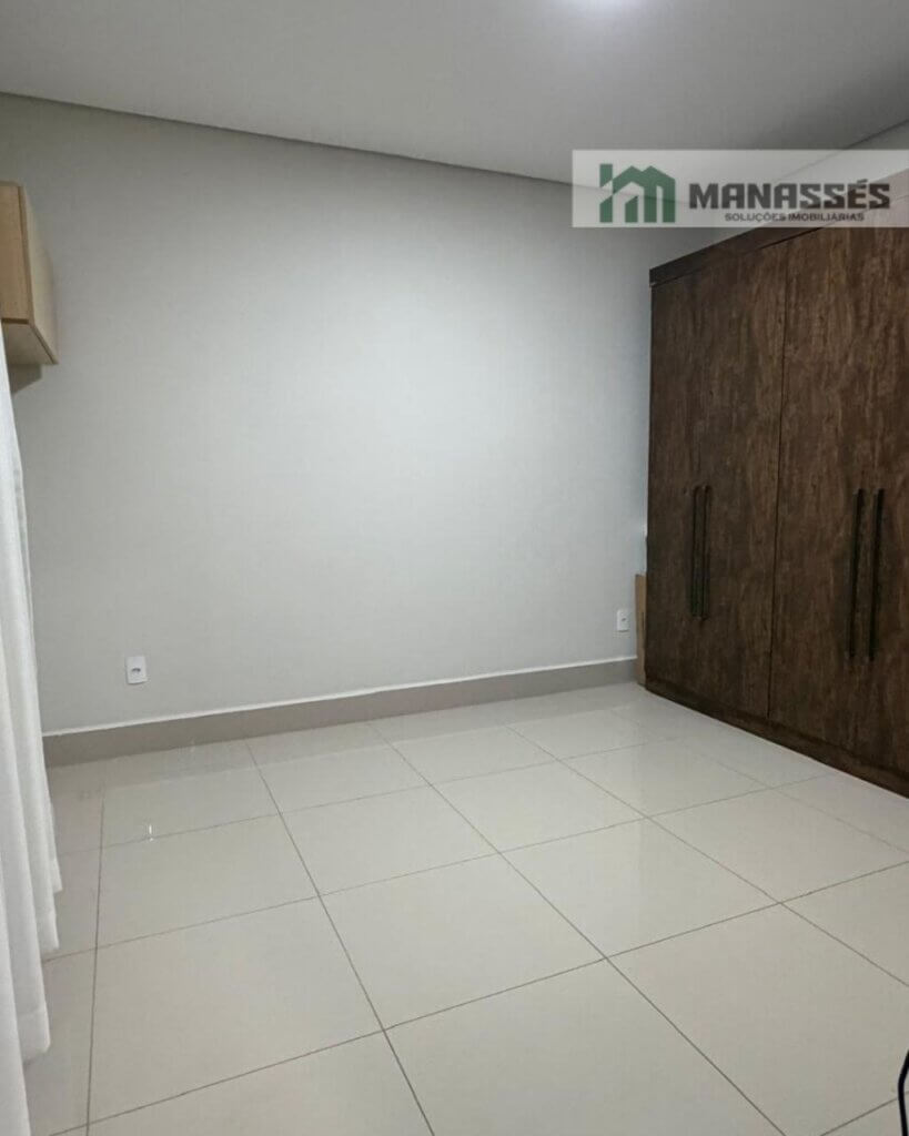 Quarto residencial com piso em porcelanato, guarda-roupa planejado e acabamento moderno em imóvel à venda em Manhuaçu.