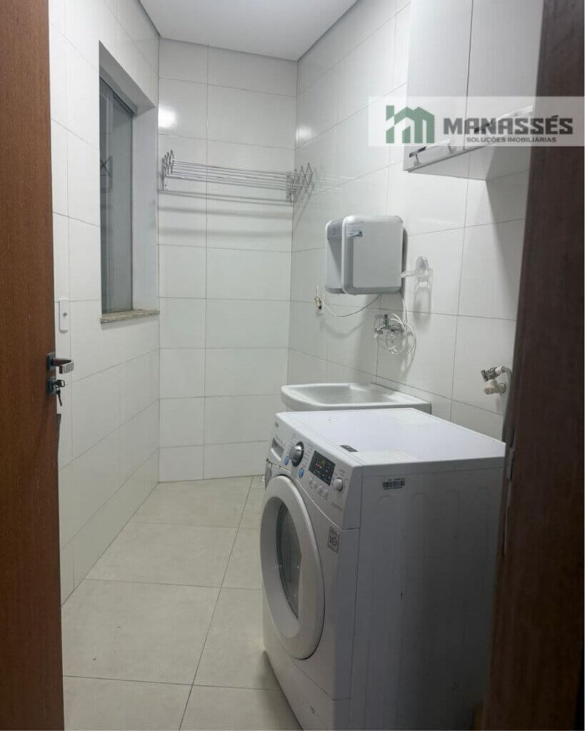 Área de serviço de apartamento no Bairro Bom Pastor em Manhuaçu/MG, com revestimento branco, tanque, aquecedor e espaço para máquina de lavar.