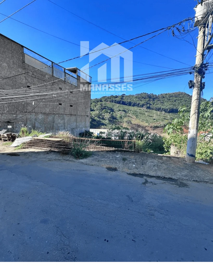 Imagem de lote urbano à venda em Manhuaçu-MG, localizado na Avenida Castelo Branco, com acesso direto pela rua asfaltada e vista ampla para área verde e BR-262.