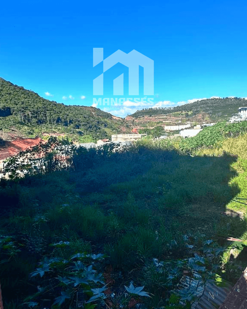 Imagem de lote urbano à venda em Manhuaçu-MG, com vegetação natural, vista panorâmica para a cidade e montanhas, ideal para construção residencial ou comercial.