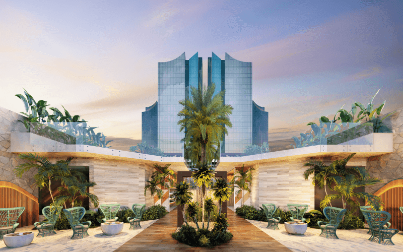 Praça de convivência do Beach Club do Taj Home Resort com jardins tropicais, mobiliário externo elegante e torres residenciais ao fundo.