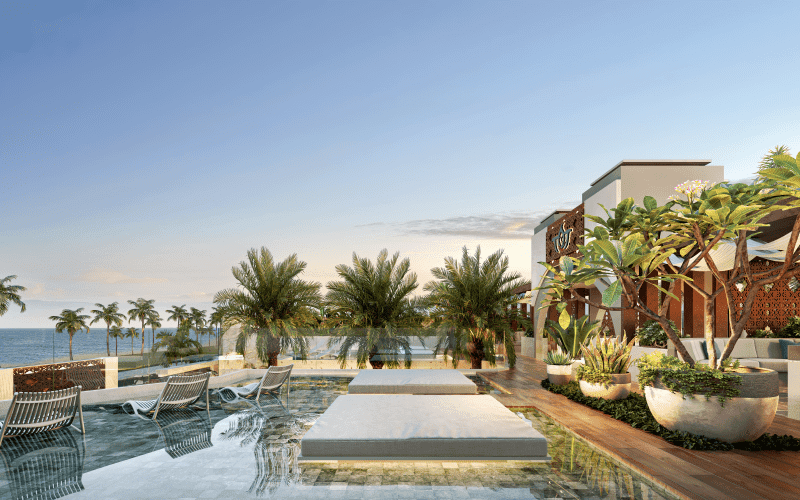 Beach Club do Taj Home Resort com piscina de borda elegante, espreguiçadeiras, paisagismo tropical e vista panorâmica para o mar.