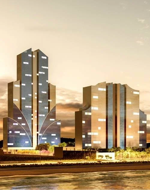 Torres residenciais do Taj Home Resort iluminadas ao entardecer, com arquitetura contemporânea e localização privilegiada próxima à orla.