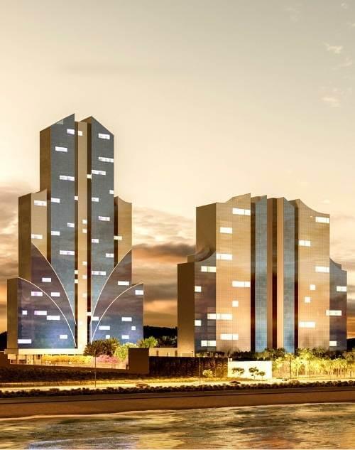 Torres residenciais do Taj Home Resort iluminadas ao entardecer, com arquitetura contemporânea e localização privilegiada próxima à orla.